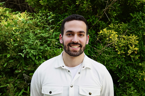 Yusuf Ben-Tarif standing in front of greenery